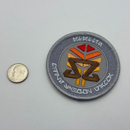 At-Attin Middle School Gamma embroidered patch placed next to a U.S. dime for size reference, showcasing the intricate details of the design.